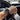 Hand wearing a watch on a car steering wheel with dashboard in the background