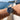 Person wearing a silver watch with a black face on a boat with water and sky in the background