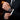 Person wearing a black suit with a watch on their wrist, blurred background