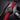 Watch with red strap and black case on a dark surface, next to a car key fob.