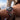 Watch with a black face, red and blue bezel on a wrist with a window view in the background