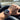 Hand wearing a watch with a road and car interior in the background