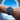 Wrist wearing a blue watch with a blue sky background