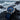 Blue watch with a detailed face on a rocky surface with ocean waves in the background