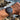 Wrist wearing a watch with a rocky coastline and ocean in the background