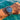 Wrist wearing a watch with a blue dial and silver case, submerged in water.