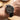Black wristwatch with silver case on a person's wrist, blurred background