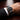 Black wristwatch on a person's wrist with a formal outfit