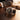 Luxury watch with black leather strap on a wooden surface, with a blurred background