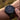 Close-up of a person wearing a detailed wristwatch with a blurred natural background