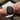 Person wearing a black watch with a green strap on an outdoor setting