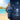 Watch with blue strap on a split background of a beach and ocean at night.