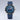 Blue wristwatch with a detailed face on a light gray background