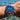 Wrist wearing a blue and silver watch with water in the background