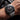 Close-up of a wrist wearing a silver watch with a black face.