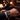 Hand wearing a watch with a blurred background of a person sitting at a table.