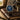 Watch with brown leather strap on a map with goggles and coffee cup in the background